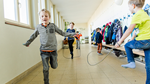 Drei Jungen springen Seil im Schulkorridor