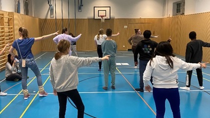 Schülerinnen und Schüler beim Proben eines Tanzes in der Turnhalle