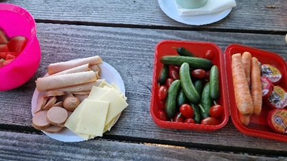 Hölzerner Tisch mit Kinder-Picknick mit Snack-Gemüse, Wurst und Käse