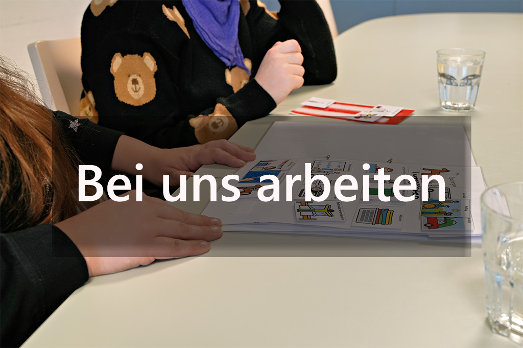Symbolbild mit einem Besprechungstisch und zwei Mitarbeitenden zum Thema "Bei uns arbeiten". 