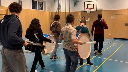 Schülerinnen und Schüler der HPZH-Guggenmusik "Turmgeister" mit verschiedenen Instrumenten beim Üben in der Turnhalle