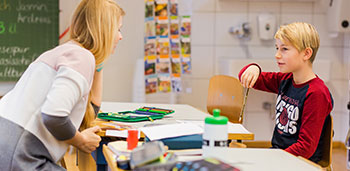 Lehrperson spricht mit Lernendem