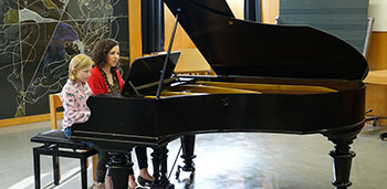 Musiklehrperson mit Schülerin am Klavier